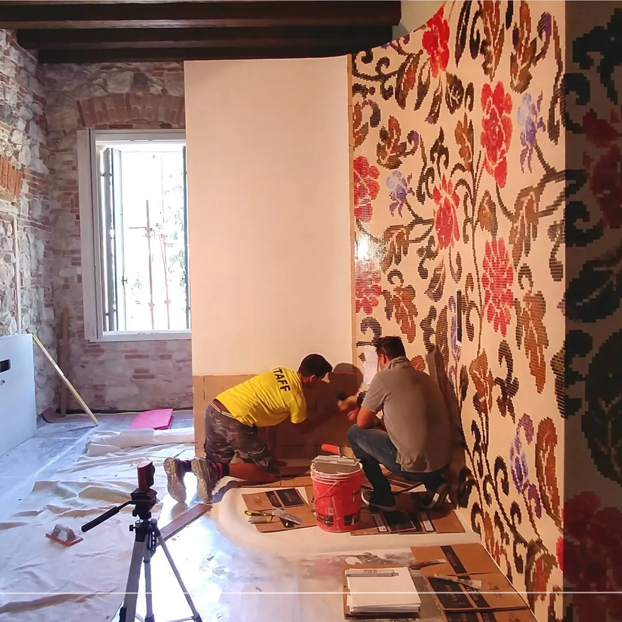 Fase di posa del mosaico su parete tonda