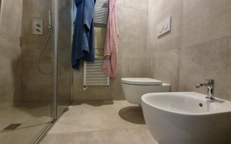 La zona sanitari e doccia del bagno di Montegalda rivestita interamente in grès effetto intonaco