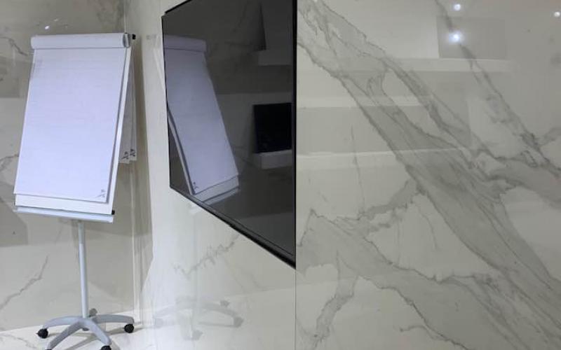 Rivestimento della parete TV con piastrelle di grande formato effetto marmo di carrara